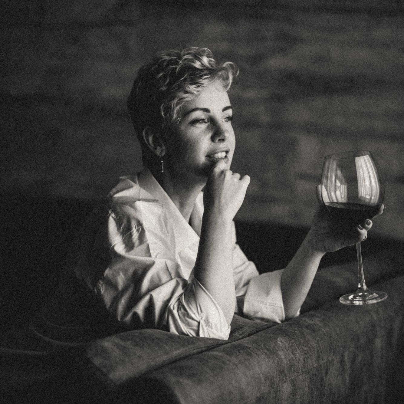 Woman in men’s shirt with wine glass, artistic and classic boudoir photography.