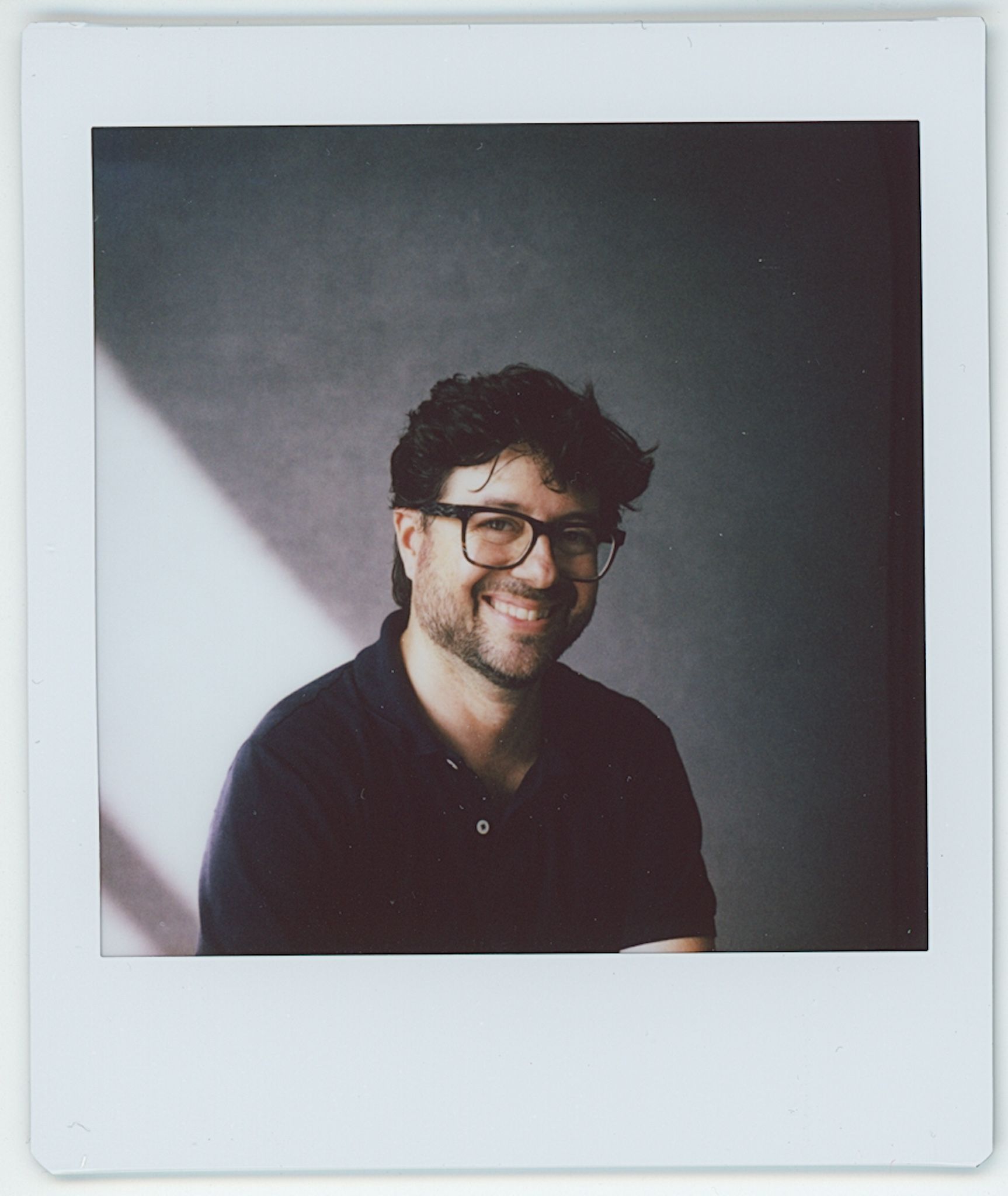 Portrait series showing a person in glasses smiling against a dark background.