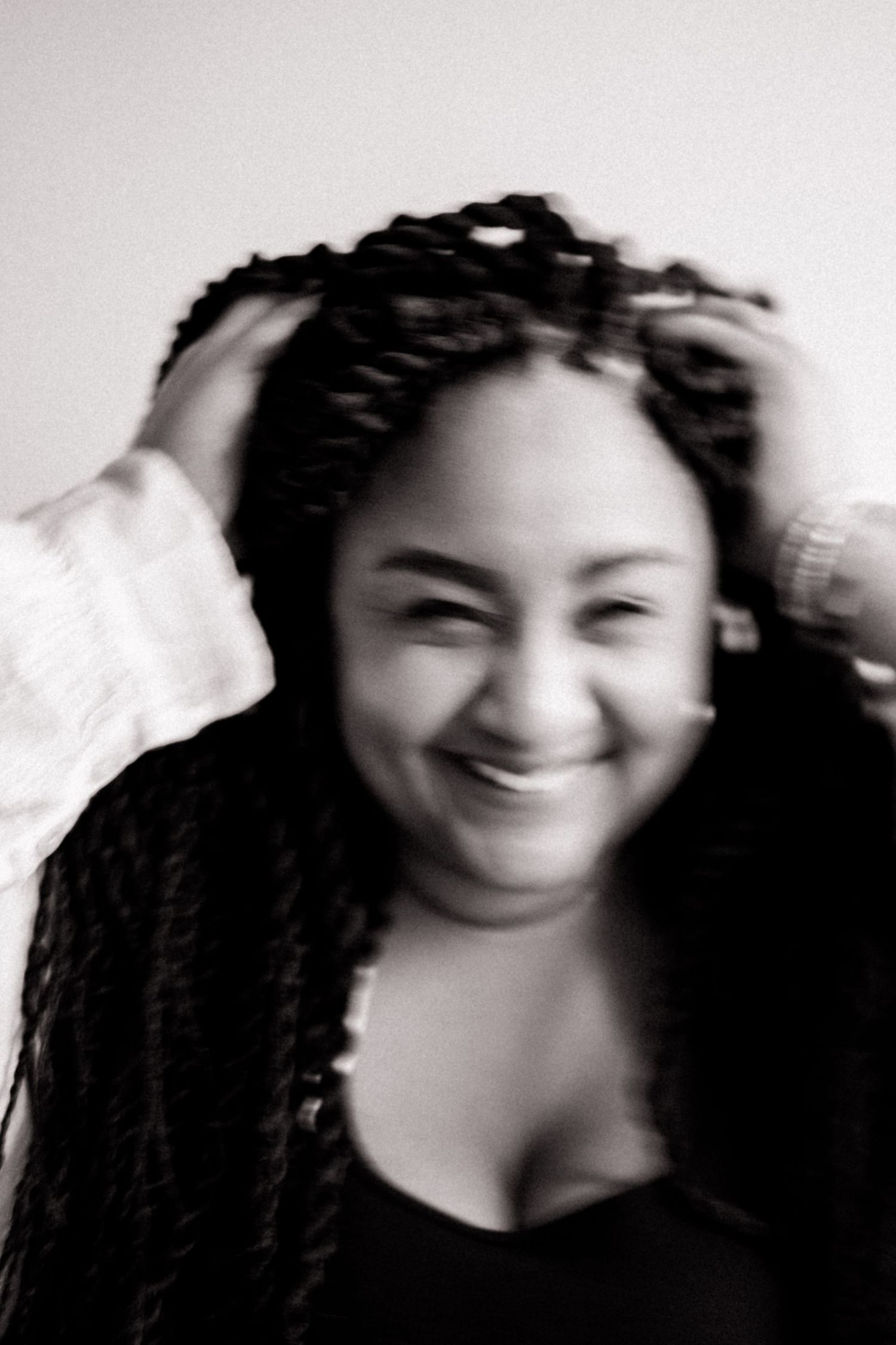 Black and white portrait of smiling woman with braided hair.