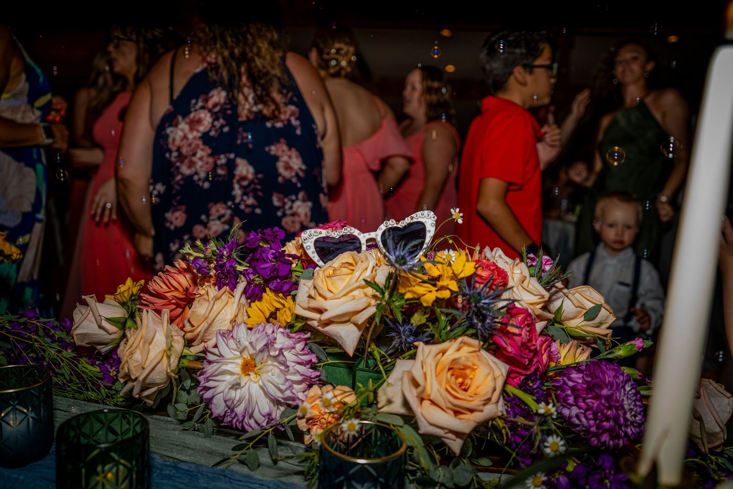 Colorful wedding bouquet with roses and mixed flowers displayed at reception.