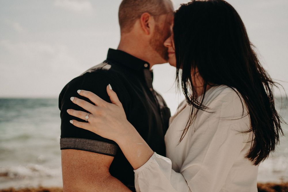 A romantic embrace captured against an ocean backdrop during golden hour photoshoot in Puerto Morelos.