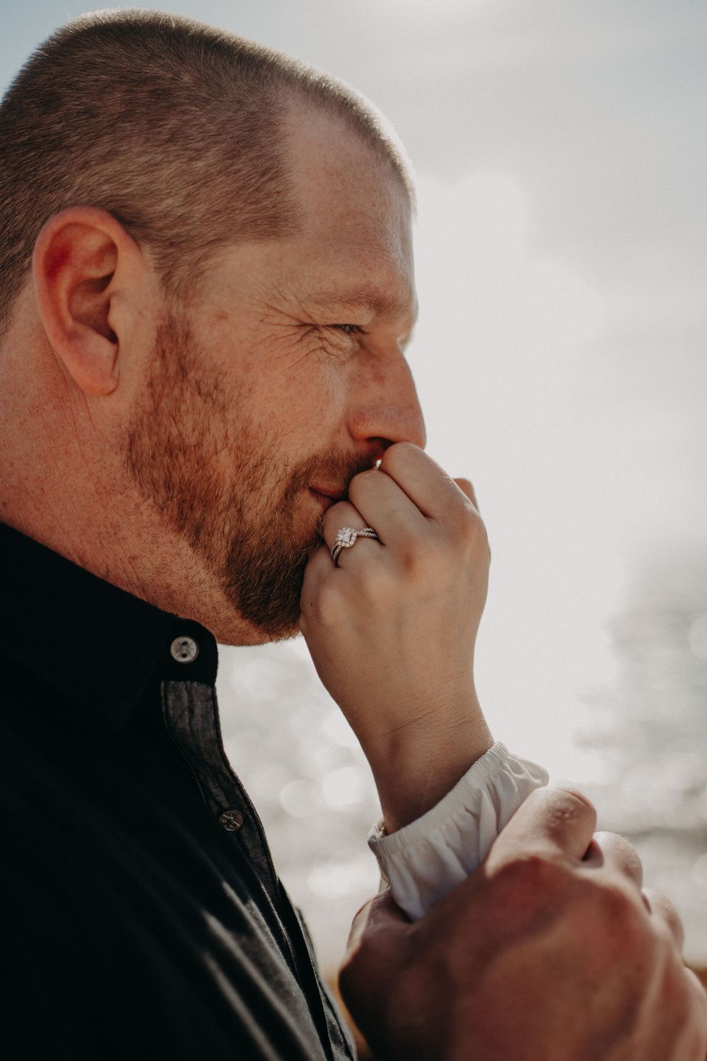 An emotional moment captured in profile against a cloudy sky background photoshoot in Puerto Morelos.