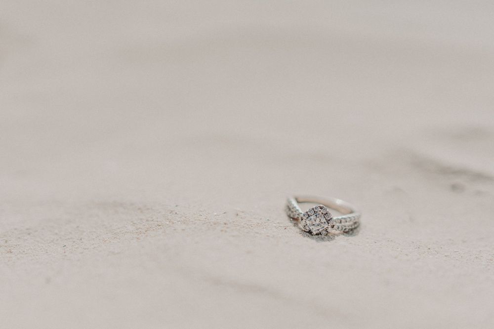 A sparkling engagement ring resting delicately on textured sand photoshoot in Puerto Morelos.