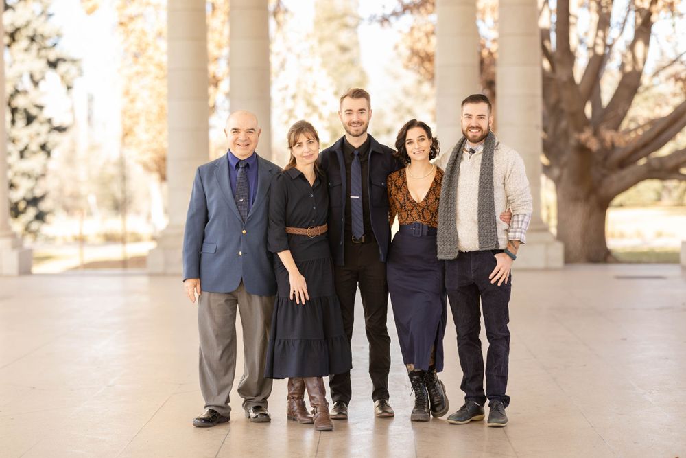 Family group photo under white columns during golden hour.