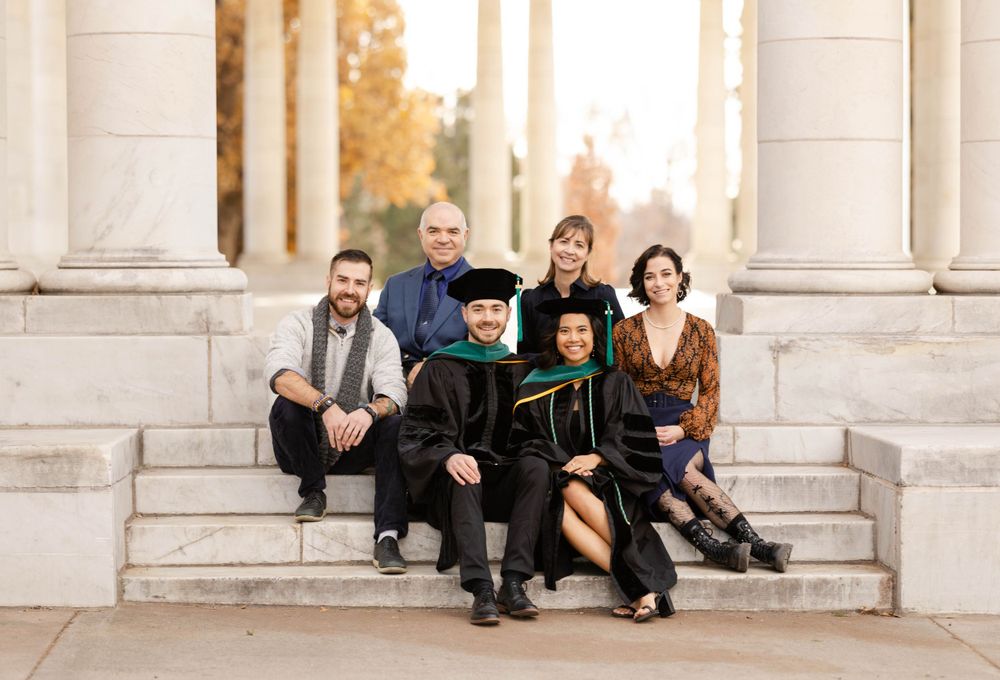 Family graduation portraits on stairs at park in Denver.