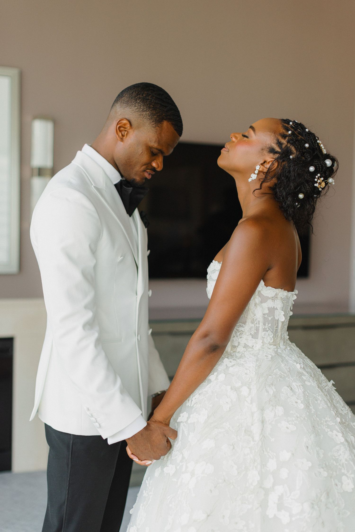 A candid moment between a couple in wedding attire showing genuine emotion and connection.