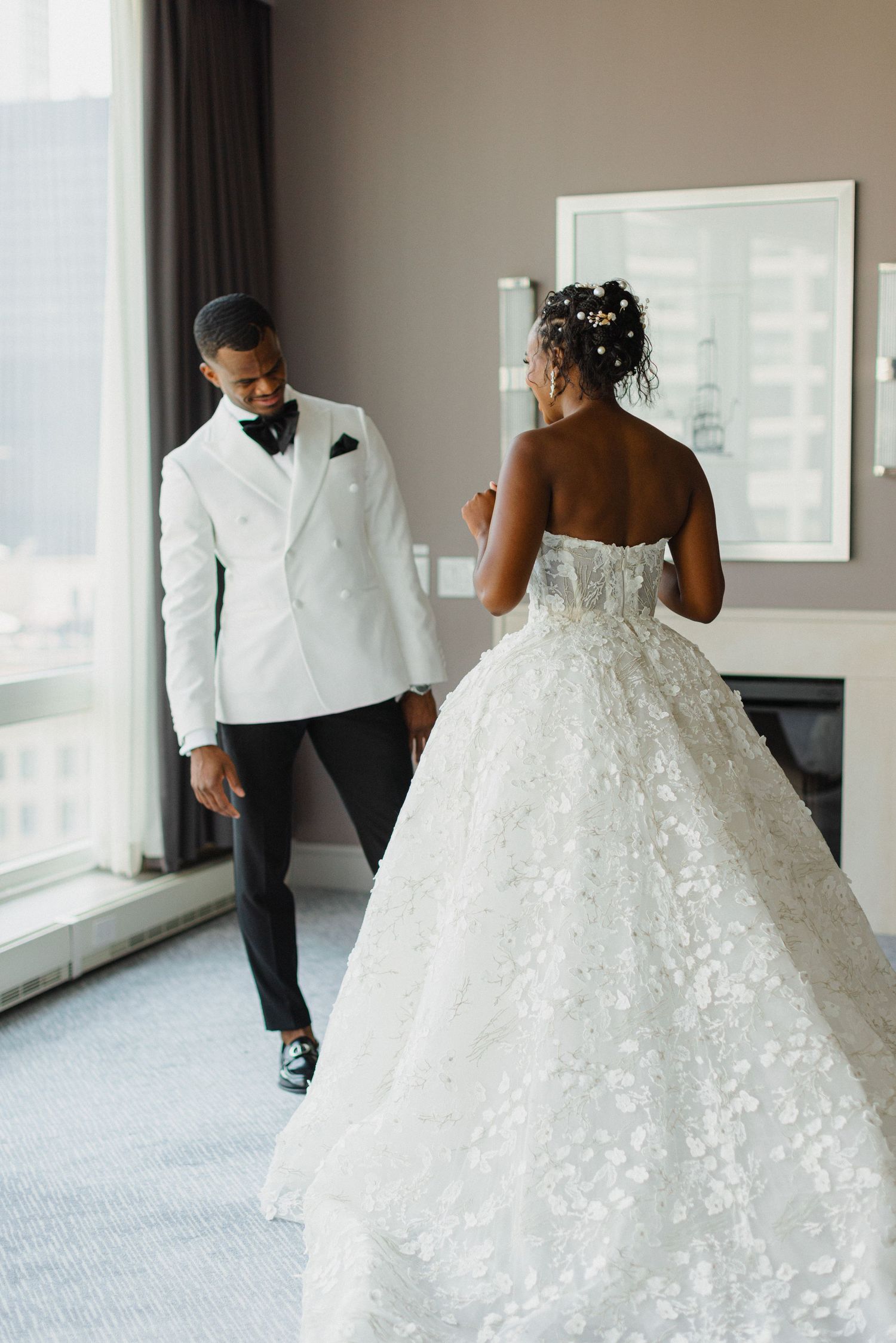 A stunning wedding gown with intricate lace details captured in a modern hotel setting.
