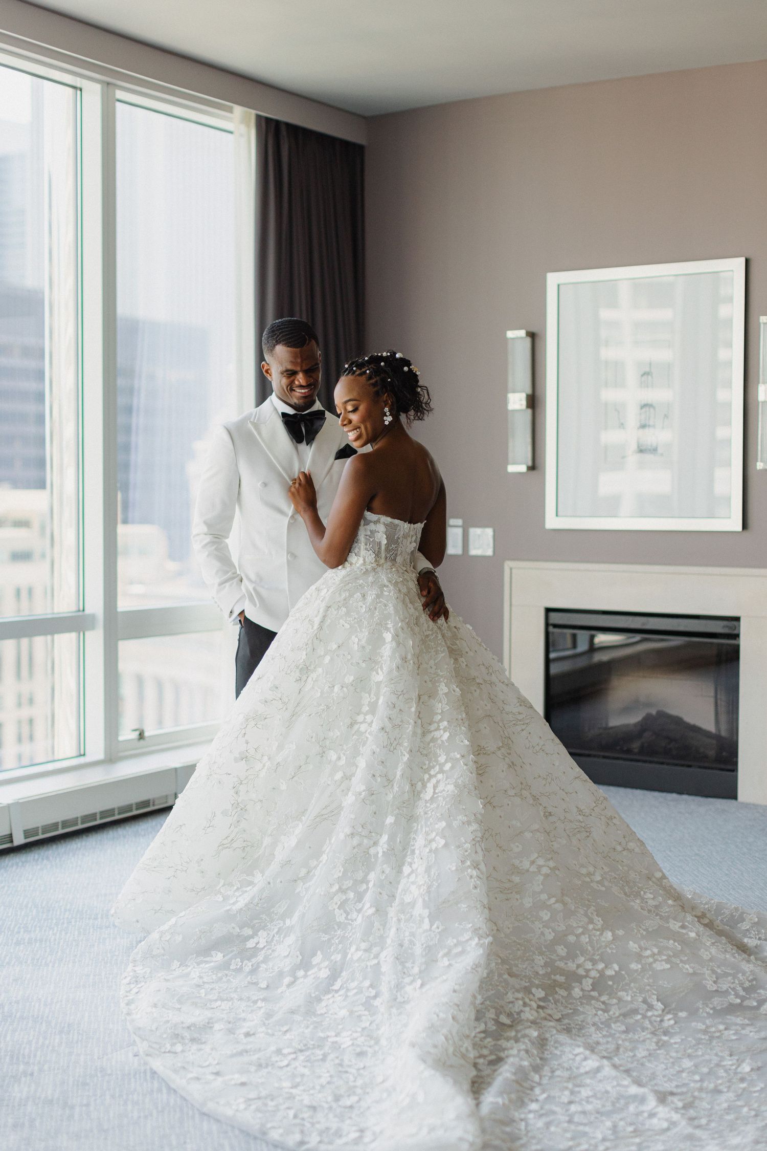 Elegant wedding portrait in a modern high-rise room with city views.