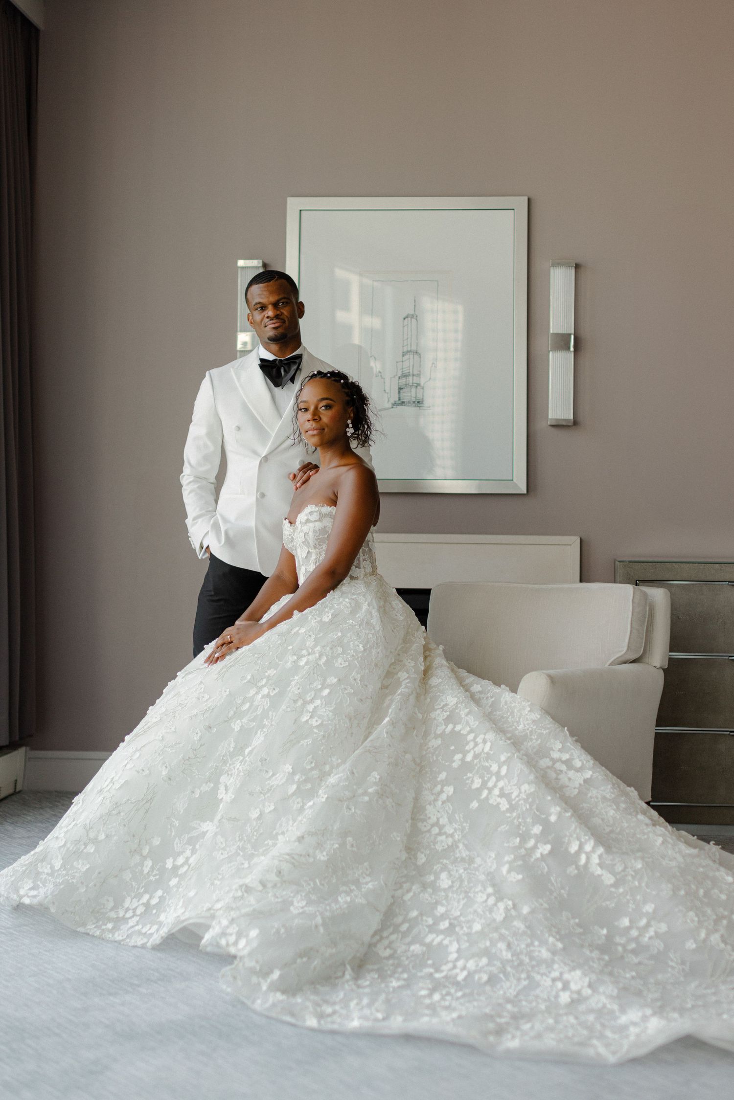 Elegant wedding portrait featuring a stunning lace ball gown in a modern room setting.