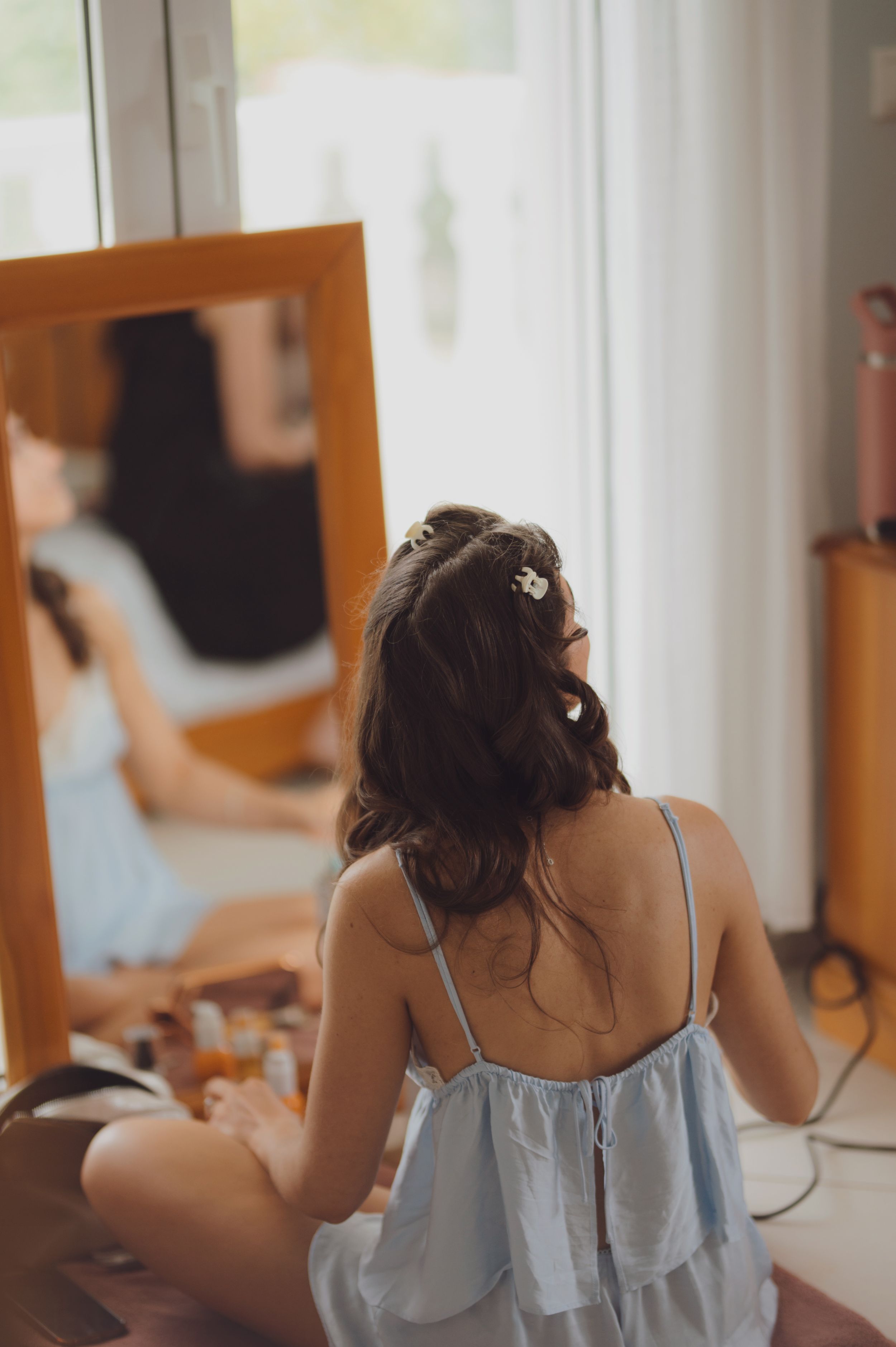 Getting ready scene with light blue robes reflected in multiple mirrors.