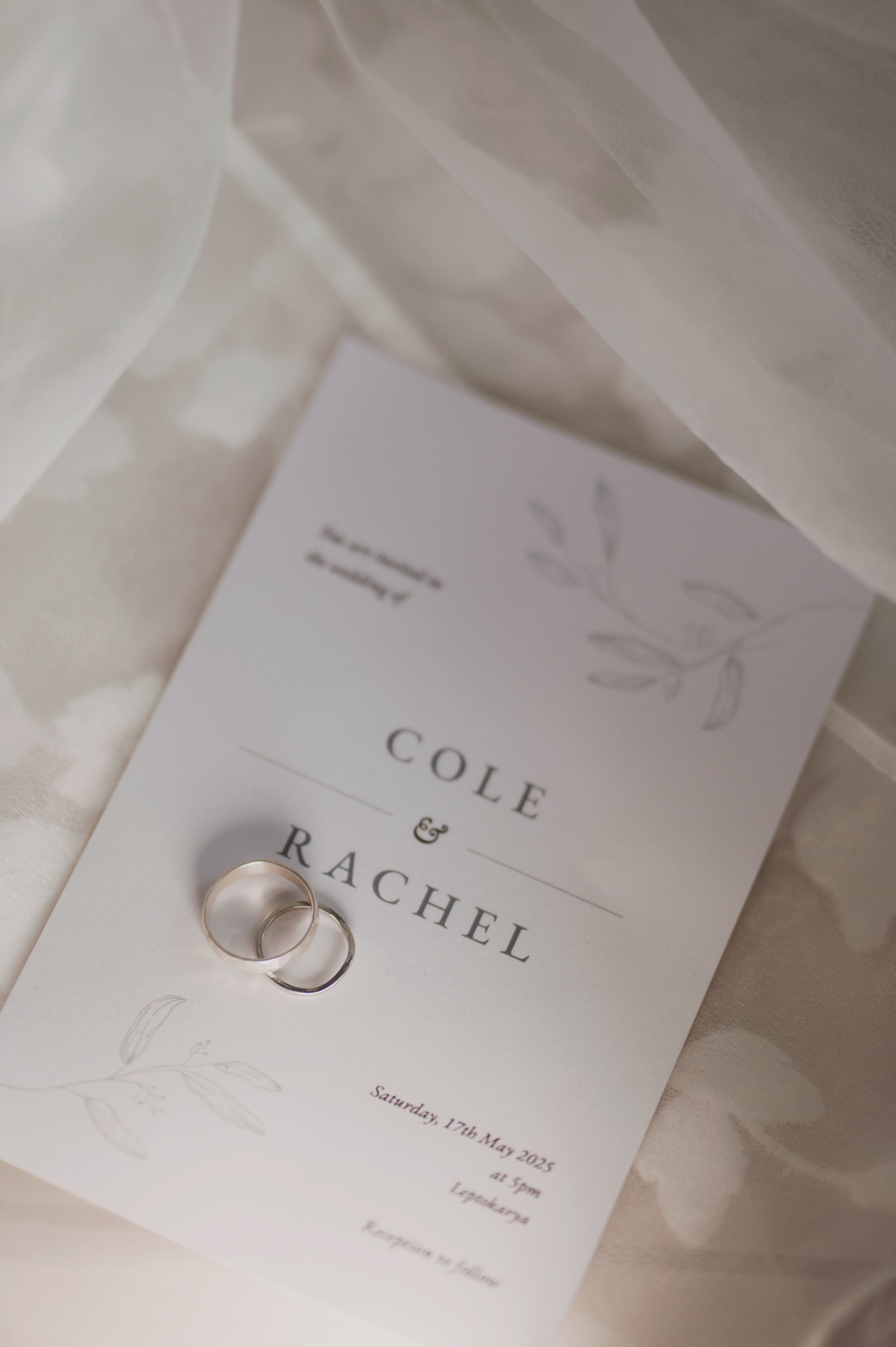 Elegant wedding invitation cards with minimalist design on white fabric.