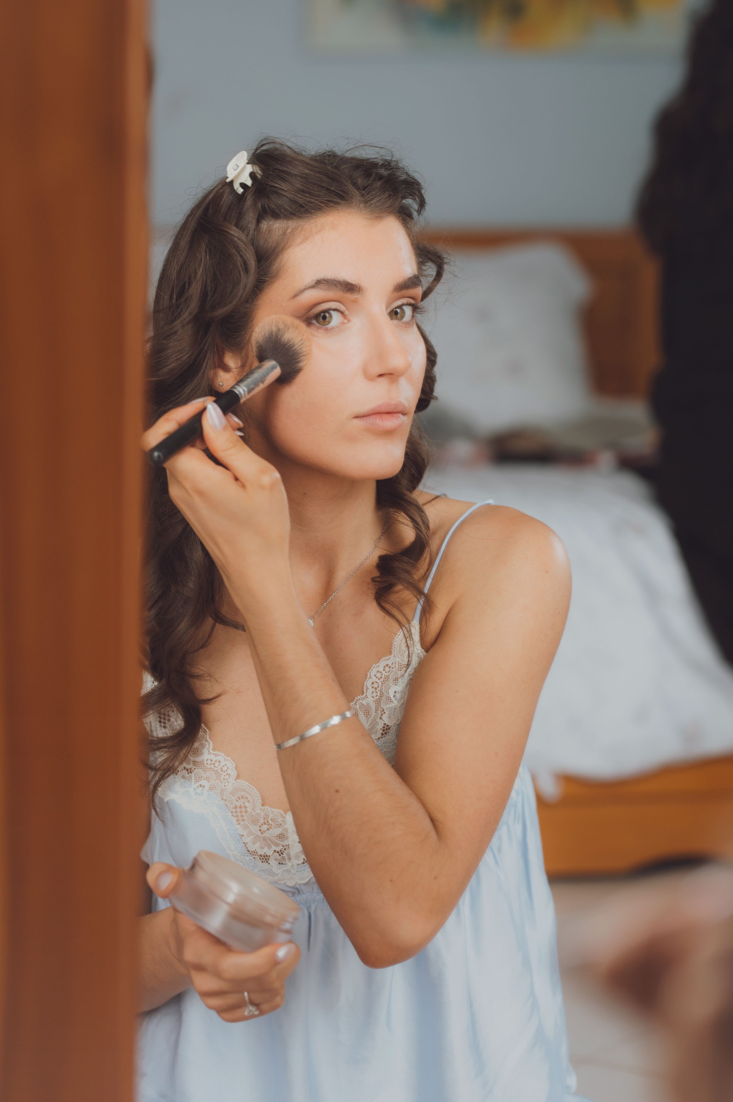 Getting ready scene with makeup brushes and styling tools in soft morning light.