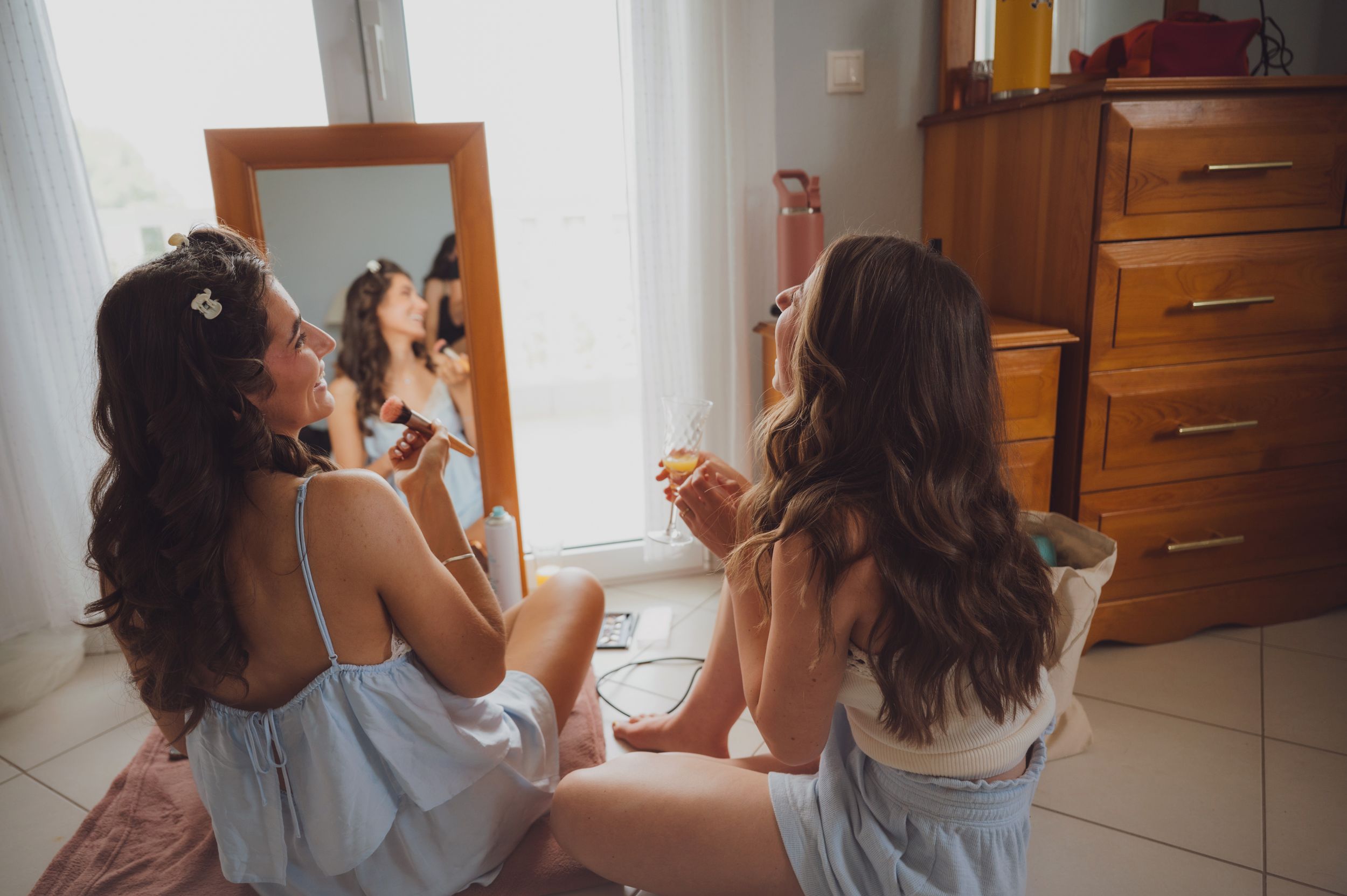 Wedding preparation scene with bridesmaids getting ready in light blue dresses.