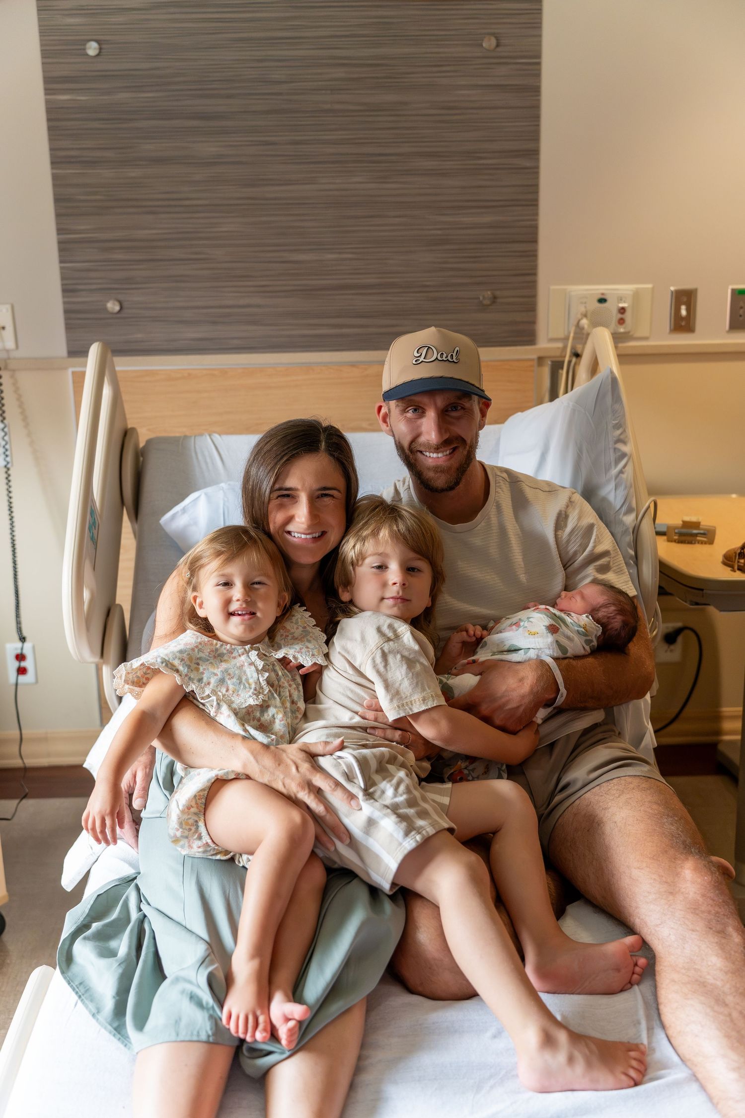 Happy family of five poses in hospital room, parents holding three children including newborn baby after birth.
UPMC Magee Fresh48 Session