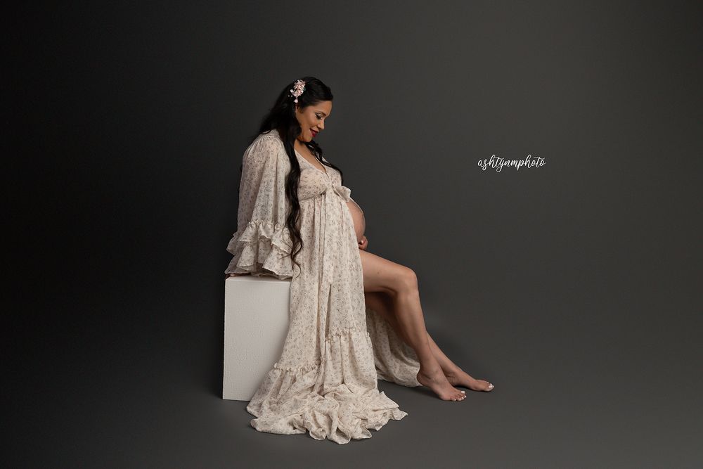 Elegant boudoir portrait series showing woman in white lace dress against grey studio backdrop.