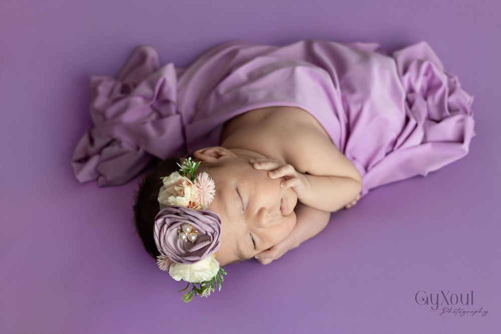 A series of six connected newborn baby photos showing peaceful sleeping poses on purple fabric with delicate floral accents.