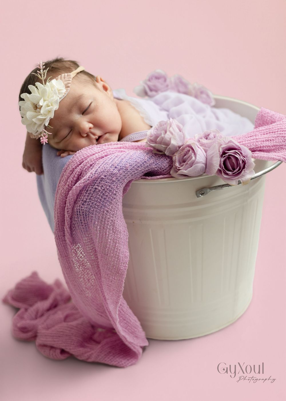 A series of soft pink newborn photography portraits featuring a white oval basin with delicate knit blankets and floral accents.