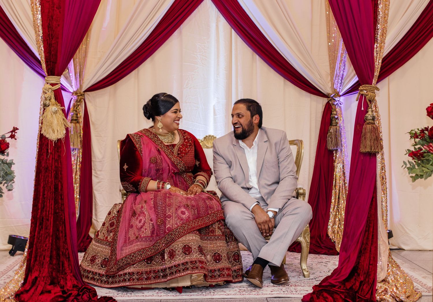 Traditional Indian wedding ceremony with burgundy and cream decor elements.
