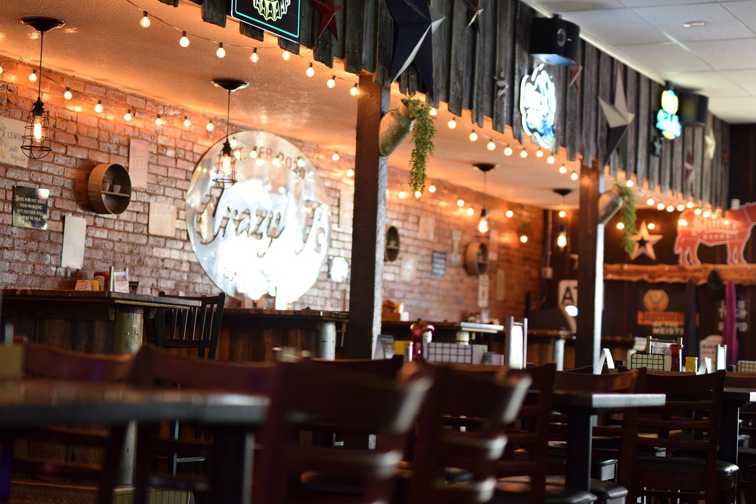 Bar interior with exposed brick walls and warm ambient string lighting.