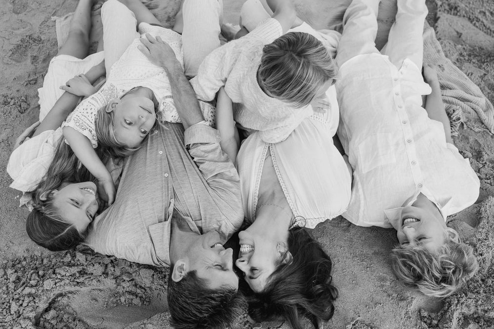 A black and white vintage photograph showing a group of people lying on the ground in a circle formation.