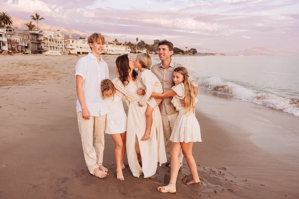 A collection of beach photos showing people in white outfits walking along the sandy shore at sunset.