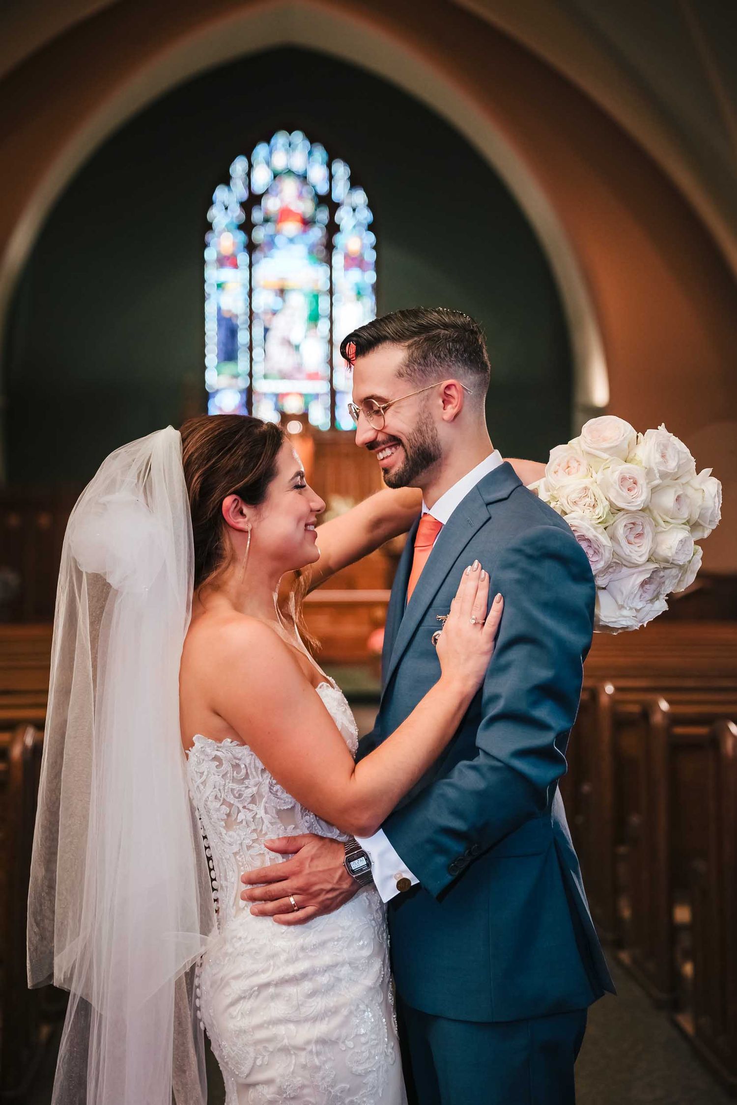 Bride and groom embracing during a romantic wedding portrait inside Saint Brigid Church in South Boston