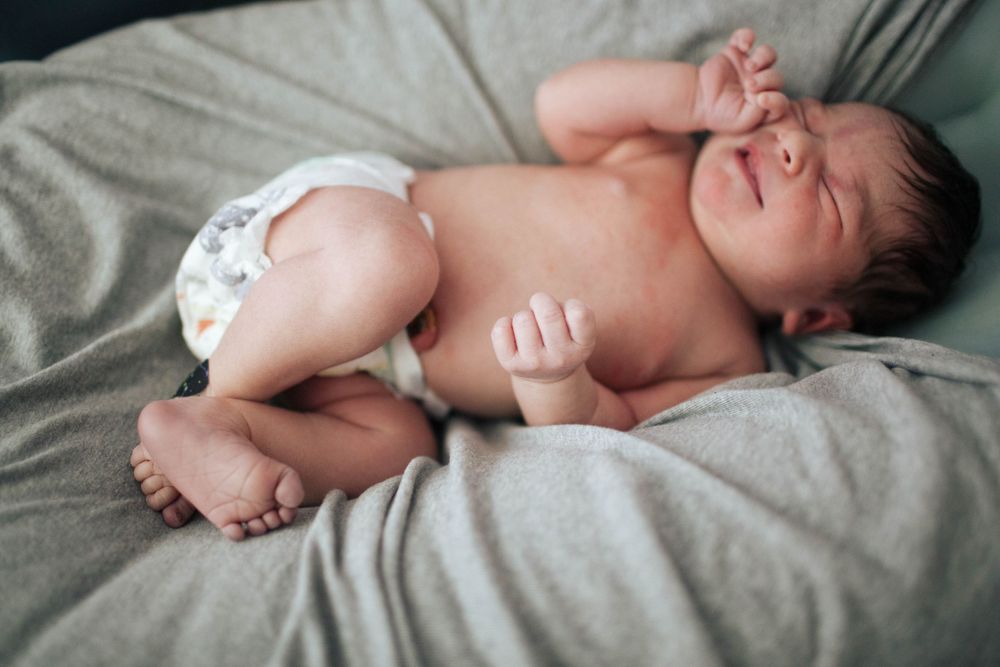 A newborn baby in natural light at home during a Fresh 48 photo session in Seattle WA