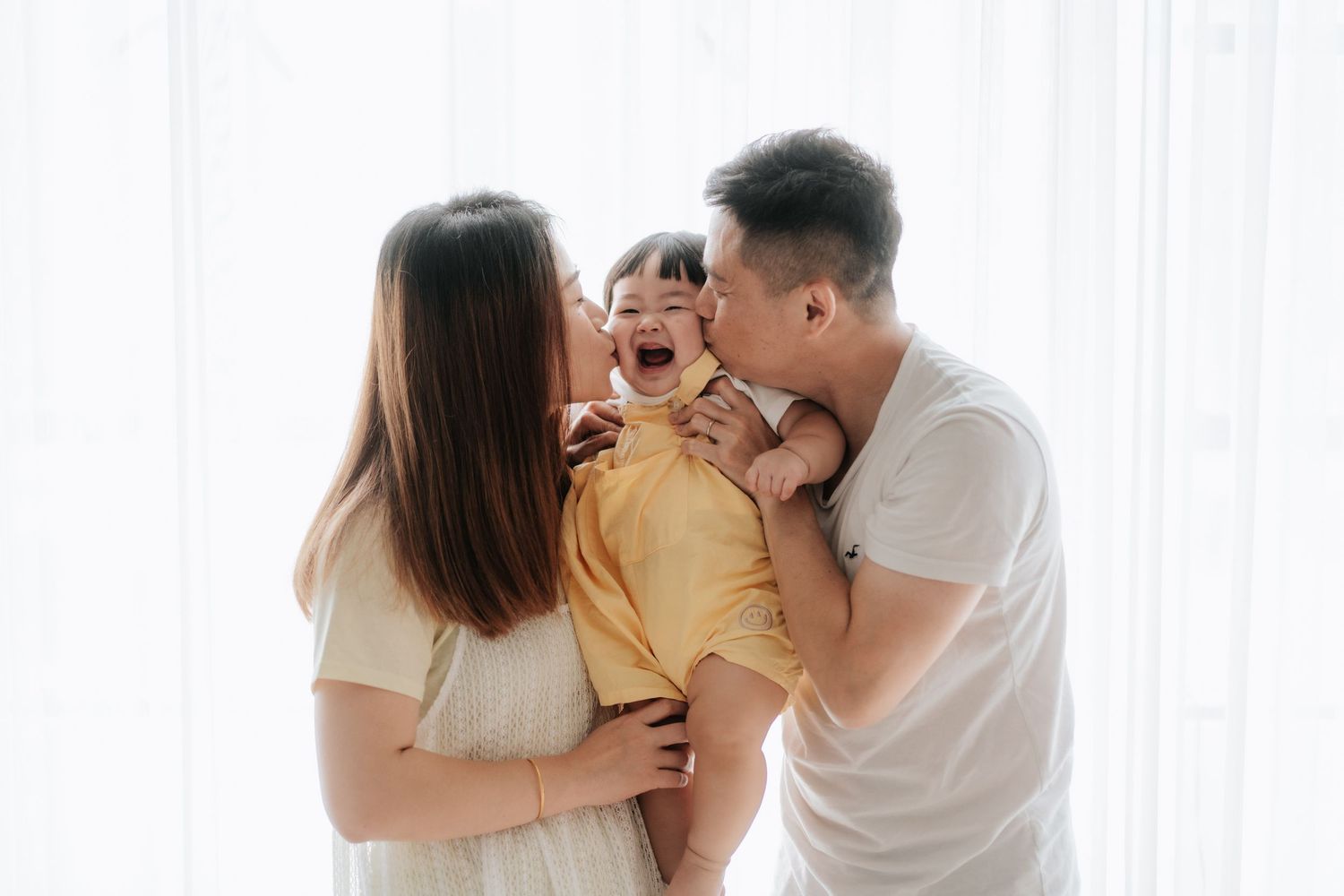 A series of tender moments between parent and baby shown in soft, warm lighting against neutral backgrounds.一系列父母與嬰兒之間溫馨的瞬間，在柔和溫暖的燈光和中性背景的襯托