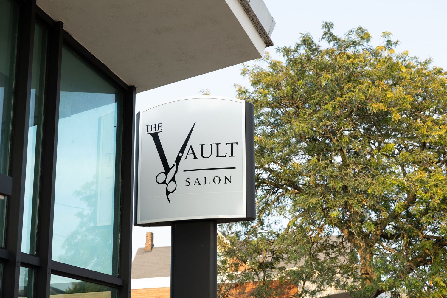 Modern storefront exterior with black trim and business signage mounted above.