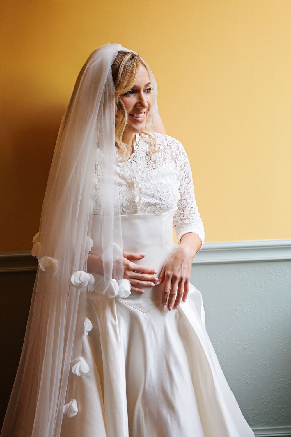 bride adjusting veil before Catholic church wedding in Houston
