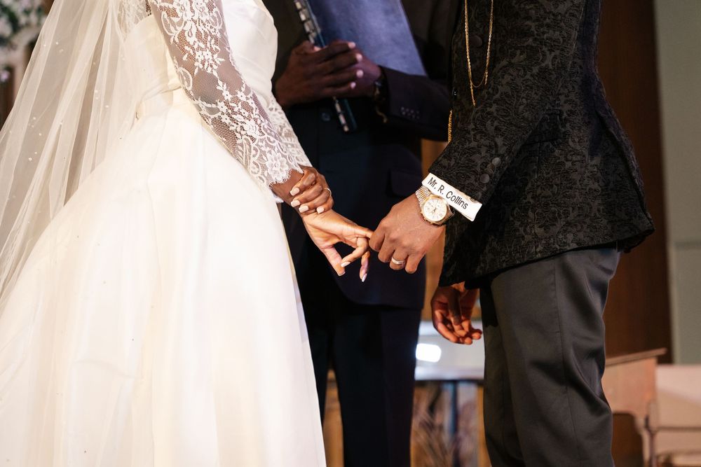 A wedding ceremony in progress with the couple and officiant standing at the altar in formal attire.