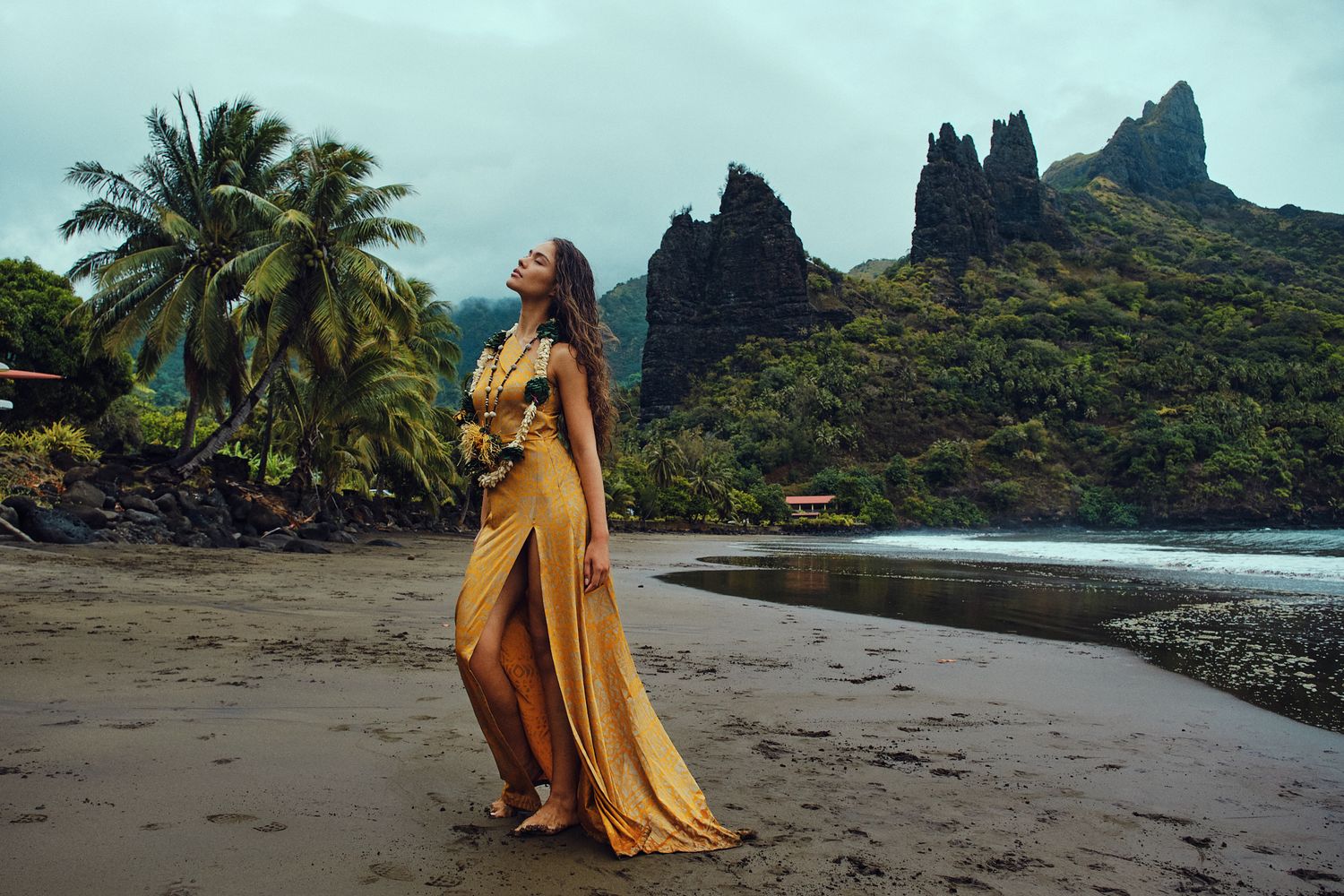 Hinaupoko Devèze (Miss Tahiti 20265 et Miss France 2026) sur la plage de Hatiheu aux îles marquises. Plan large sur la plage et la montagne.