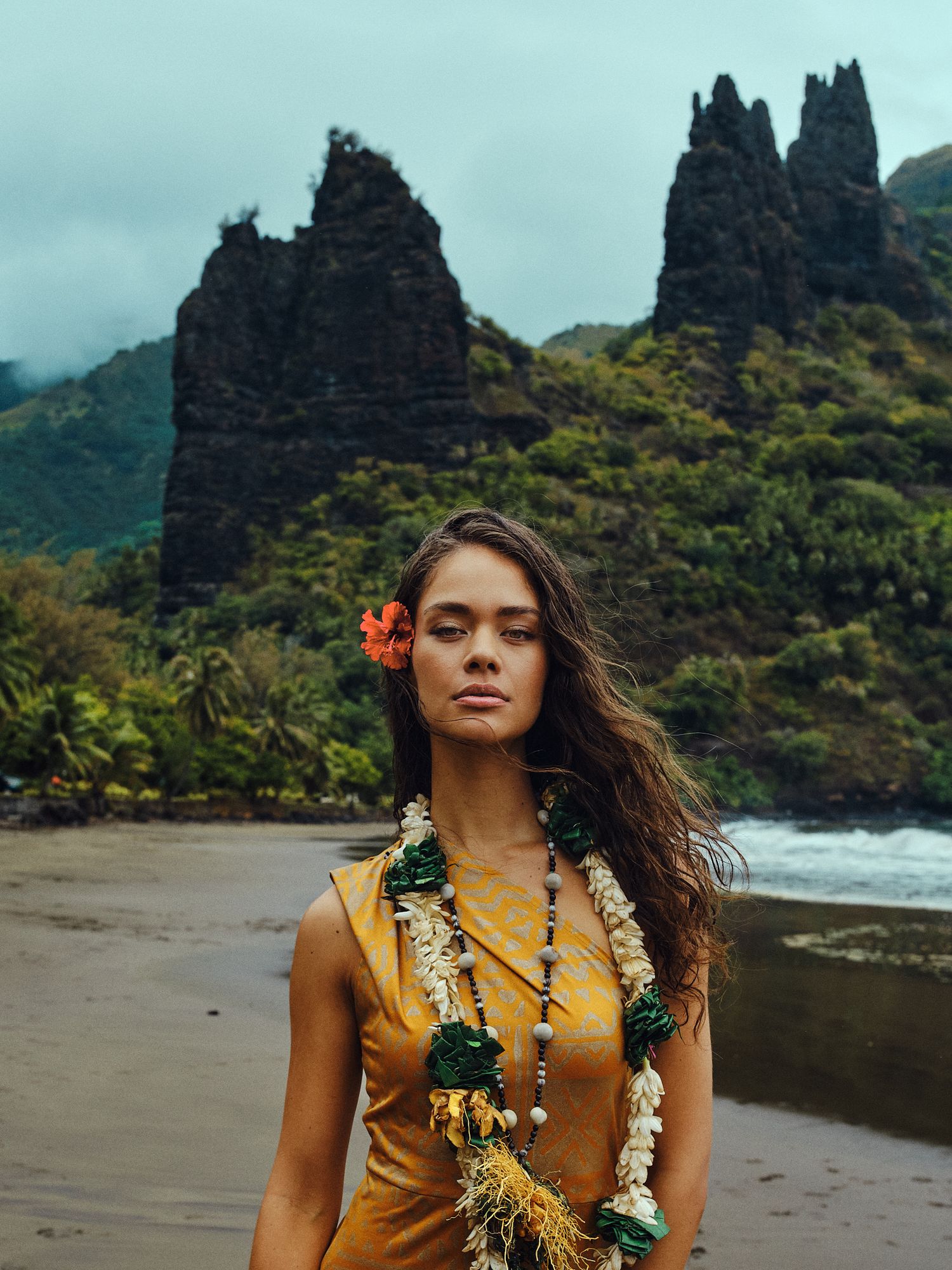 Hinaupoko Devèze (Miss Tahiti 20265 et Miss France 2026) sur la plage de Hatiheu aux îles marquises. Plan large sur la plage et la montagne.