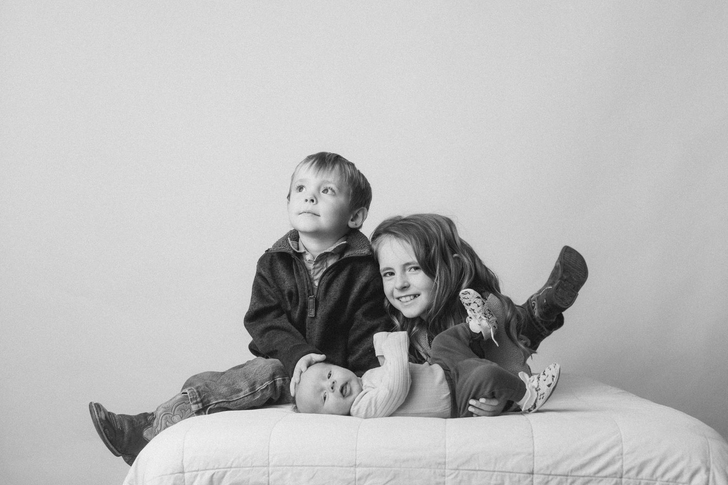 Black and white photo series showing tender moments between parent and baby in intimate poses.