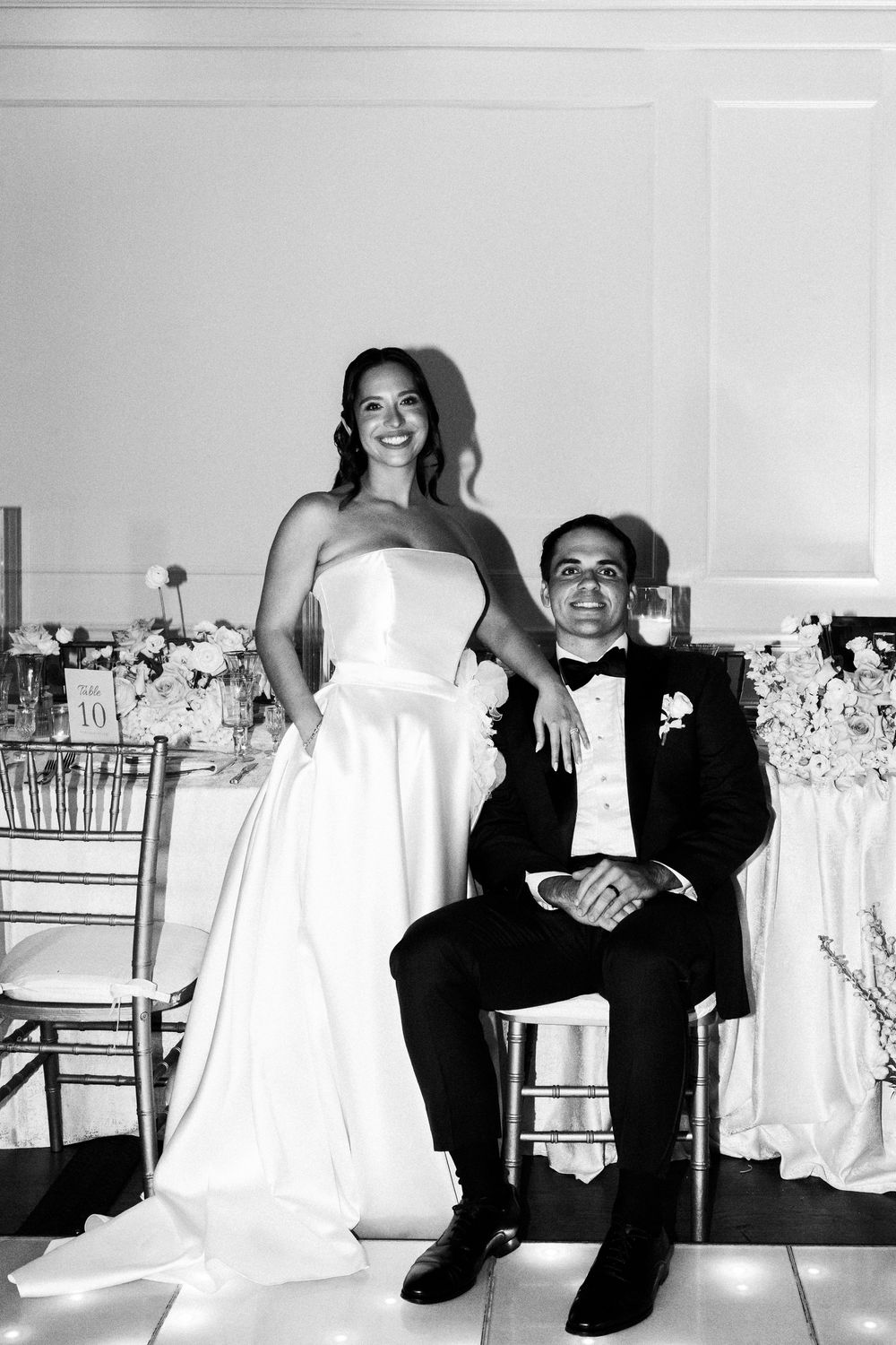 A series of black and white wedding photos showing playful moments between a couple in formal attire.
