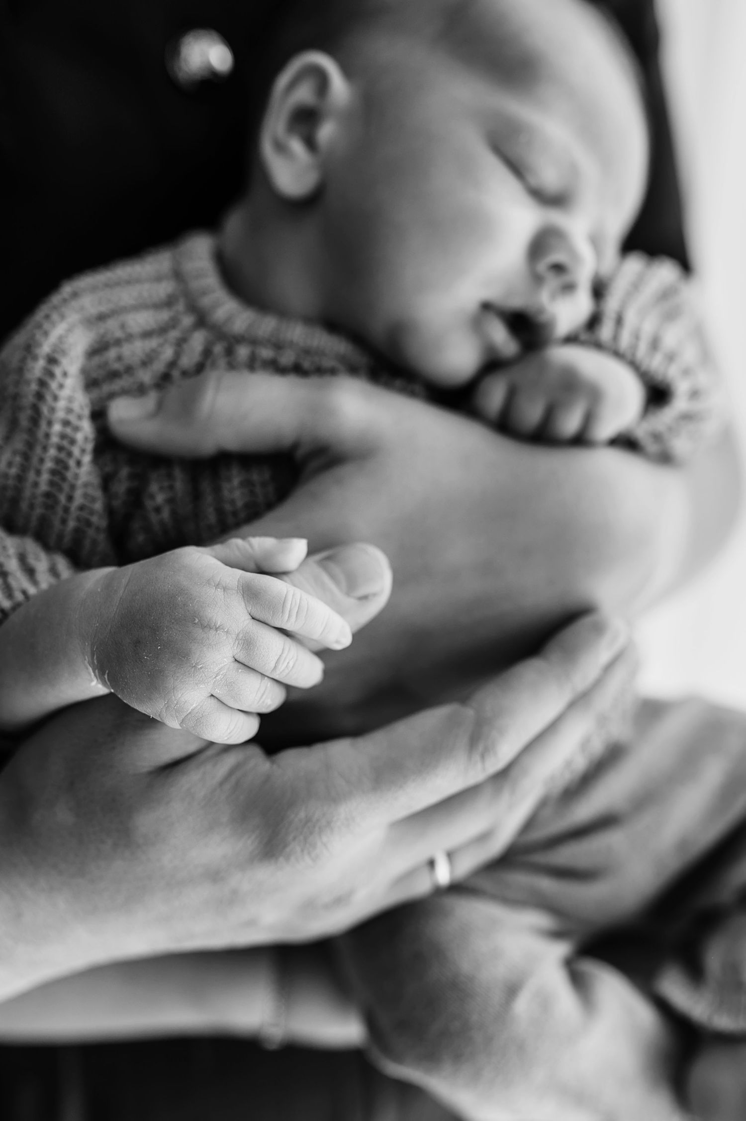 A tender black and white photo series showing small hands gently touching and resting on an adult's hand.