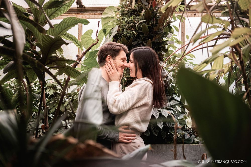 Intimate couple portraits framed by lush green foliage in a greenhouse setting.