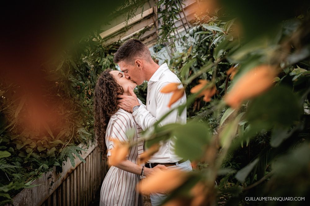 Intimate greenhouse photoshoot with soft lighting and natural greenery.