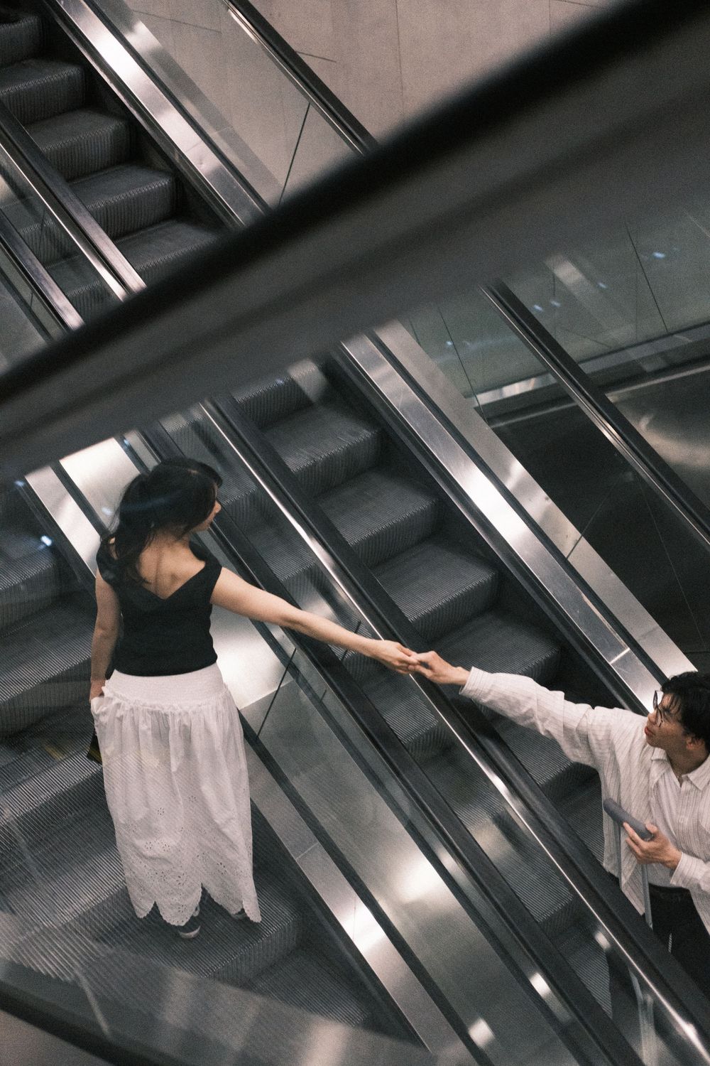 A sequence of images showing someone in white clothing reaching up towards fluorescent lights in a dark hallway.