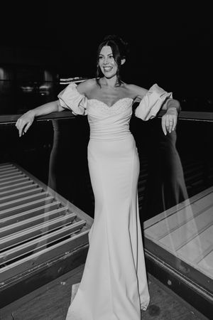A person in a white wedding dress stands at a bowling alley lane, creating a unique and playful photo series.
