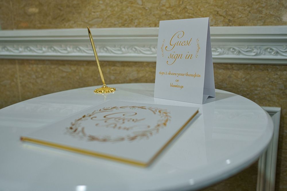 Elegant white and gold wedding invitation cards and envelopes arranged on a textured surface.