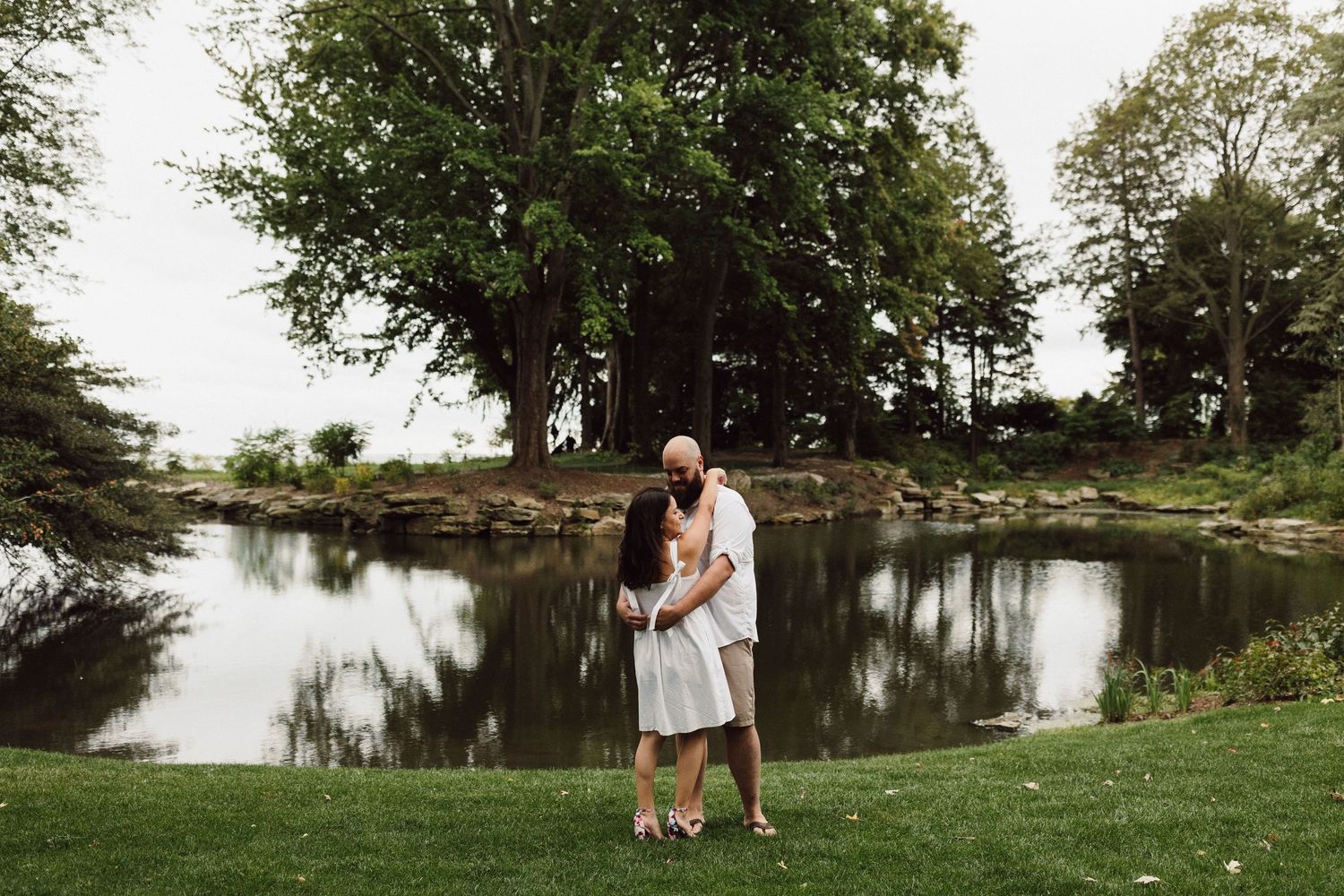 A scenic lakeside setting with trees and greenery reflecting on calm waters.