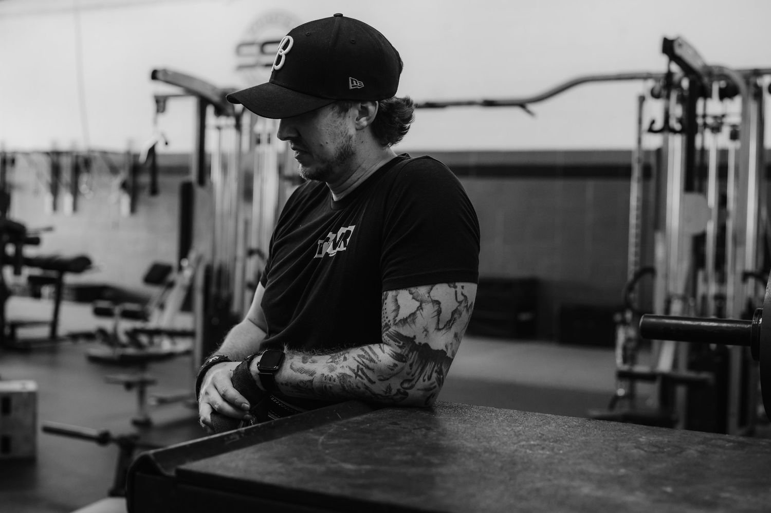 A series of black and white photos showing someone performing exercises at a gym facility.