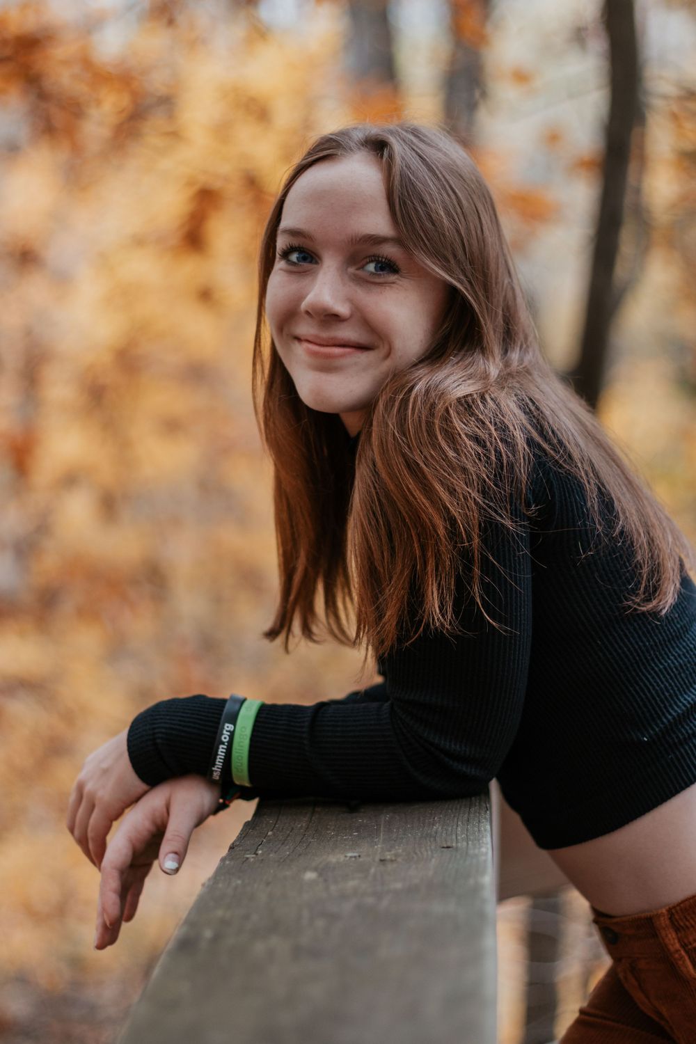 Artistic portrait series showing playful expressions while leaning on wooden railing outdoors.