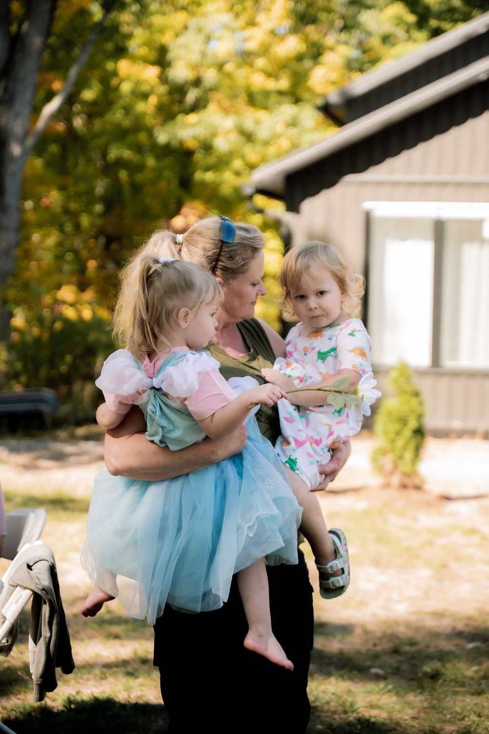 A series of outdoor photos showing playful spinning and dancing moments in blue and pink dresses against a natural backdrop.