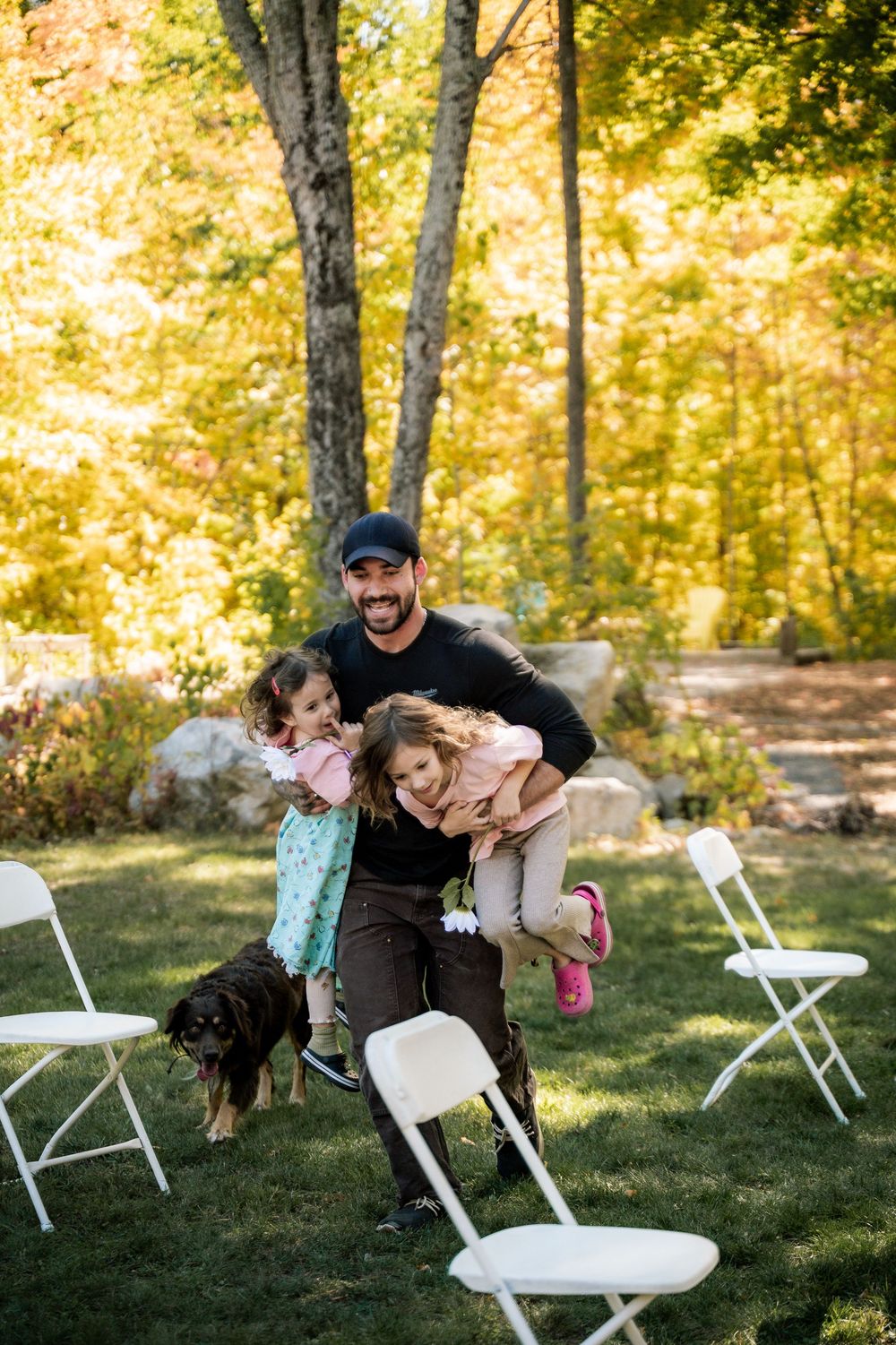 A playful outdoor scene with white folding chairs on grass during golden hour.