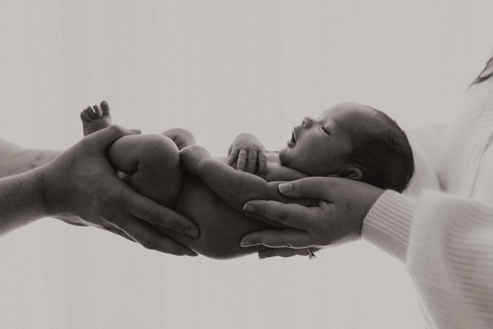 A series of black and white photographs showing hands reaching out and connecting with each other.