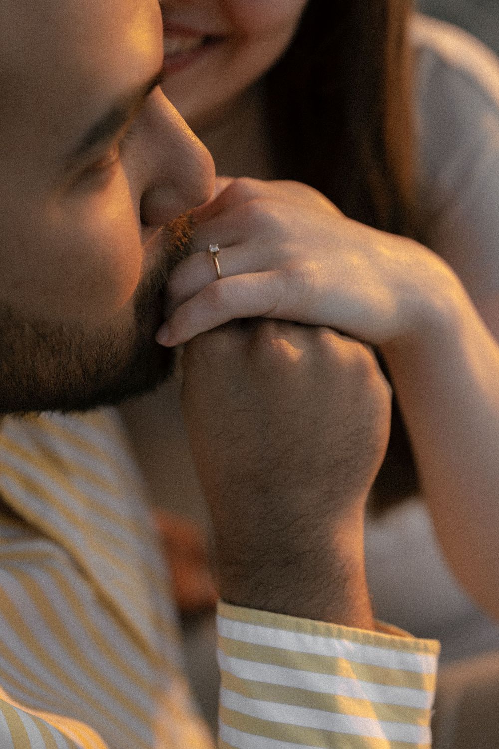 Close-up artistic detail of white fabric against skin in warm lighting.