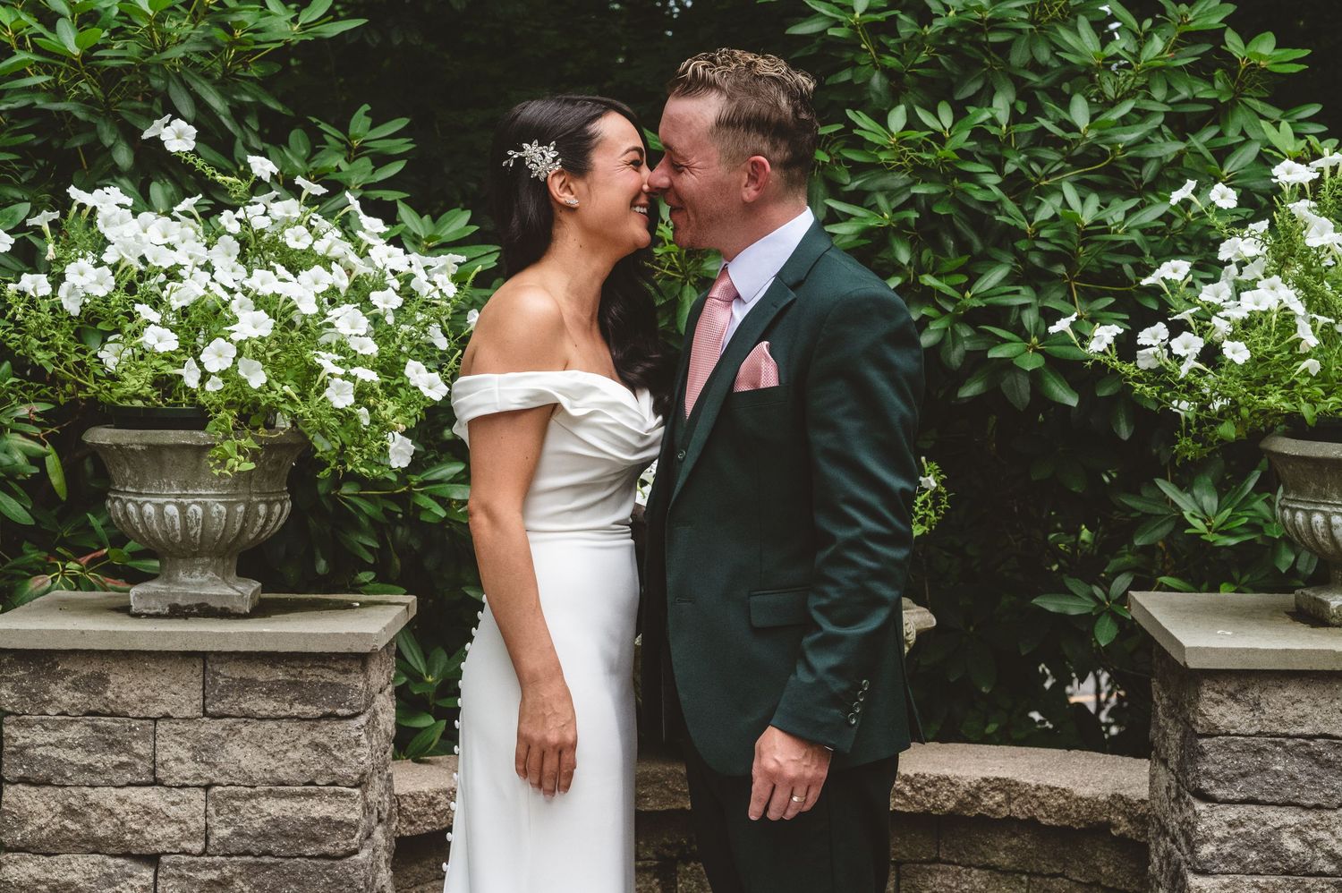 Romantic wedding moment of a couple kissing at the Delaney House in Holyoke, Massachusetts surrounded by lush gardens and stone architecture