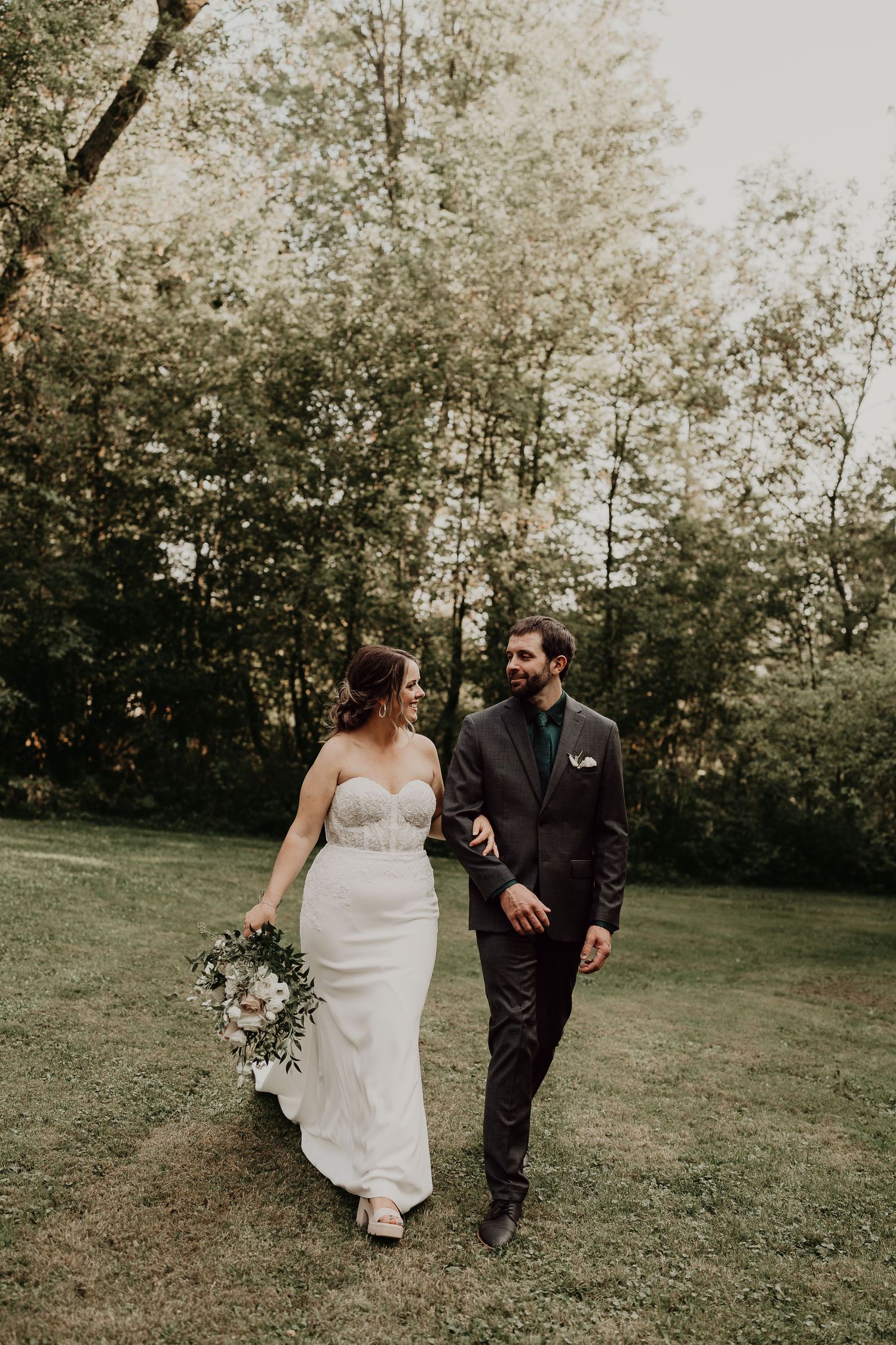 bride and groom walk together arm in arm